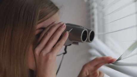 Girl observed with binoculars outside her home.
