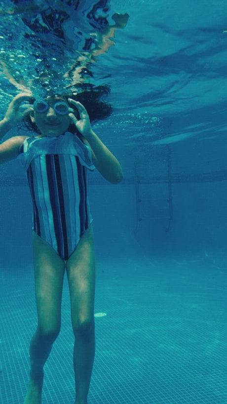 Girl playing in a pool underwater.