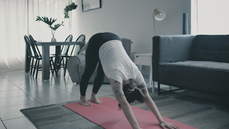 Girl practicing yoga in a living room at home.