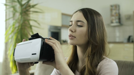 Girl putting on VR glasses.