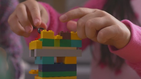 Girl putting together a figure with legos