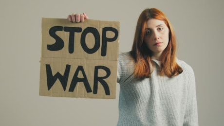 Girl raises up a Stop War sign.