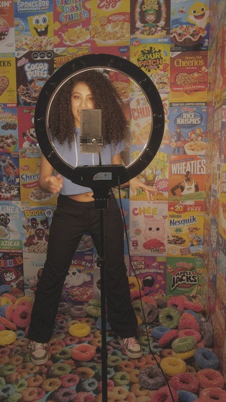 Girl recording a video on a background of cereal boxes