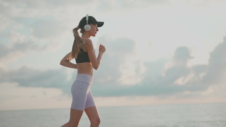 Girl running and listening music outdoors.