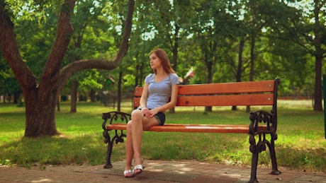 Girl sitting on a bench waiting for someone