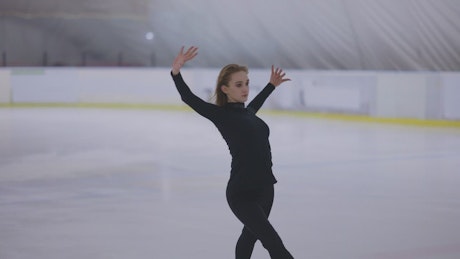 Girl skater practicing figure skating routine.