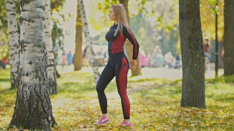 Girl stretching and warming up in a sunny park