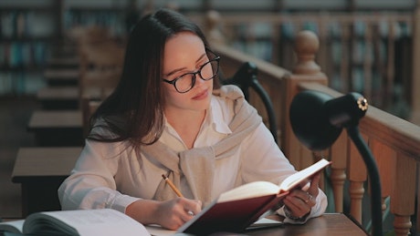 Girl studies late in library to prepare for exam