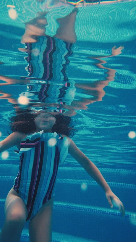 Girl underwater in a pool.