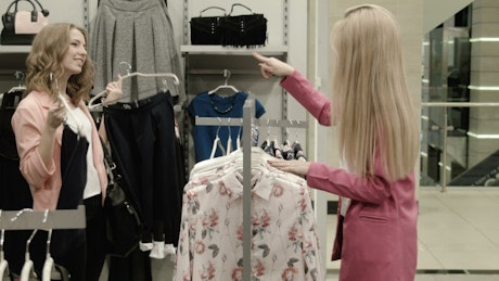 Girls choosing dresses on a clothing store.