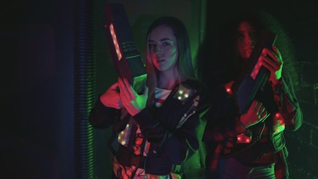 Girls posing with laser tag blasters.