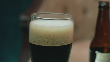 Glass with foamy dark beer.