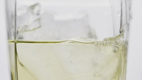 Glass with Ginger Ale and lemon on white background.