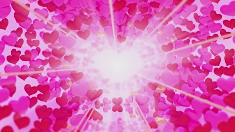 Glowing light at the end of a tunnel of 3D hearts.