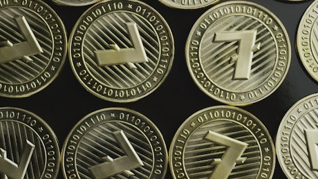 Golden Lite coins on a black surface.
