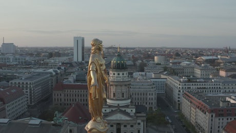 Golden statue and the city in the background.