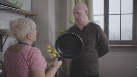 Grandma threatens grandpa with frying pan.