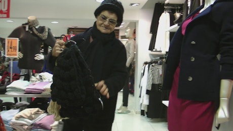 Grandmother choosing winter clothes in the mall.