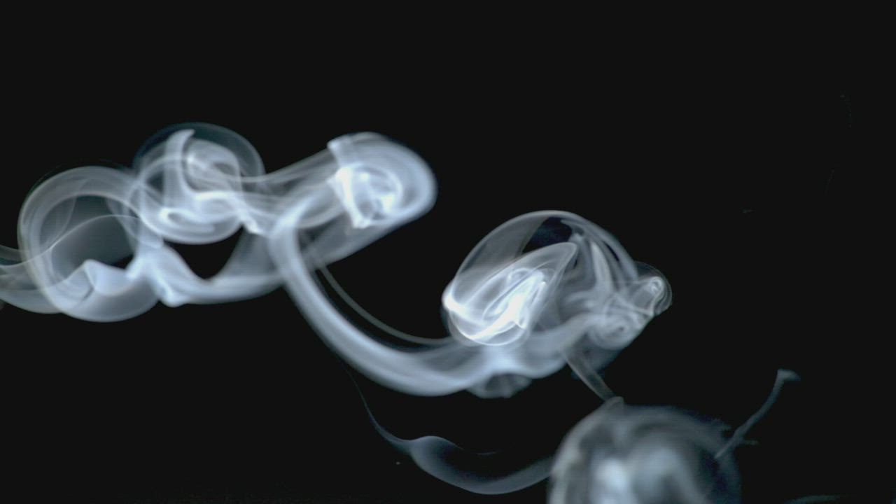 Grey smoke swirls over a black background - Free Stock Video