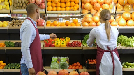 Grocery clerk smelling oranges