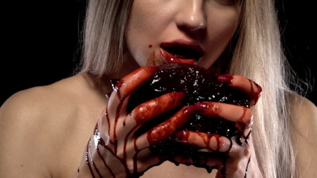 Gross close up of a woman holding a bloody heart.