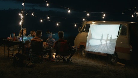 Group of friends watching a movie with a projector.
