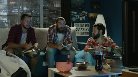 Group of men playing video games at home.