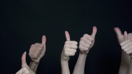 Group of people giving a thumbs up.