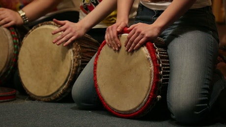 Group of percussion musicians playing Djembe drums.