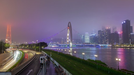 Guangzhou illuminated cityscape with cloudy sky.