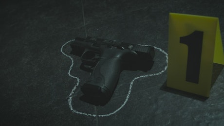 Gun and some bullets on the ground at a crime scene.