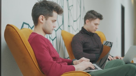 Guys making homework in a co-working space.