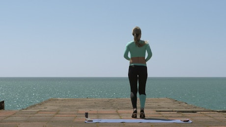 Gym aerobics exercises on a pier.