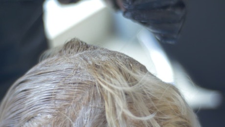 Hairstylist applying hair dye