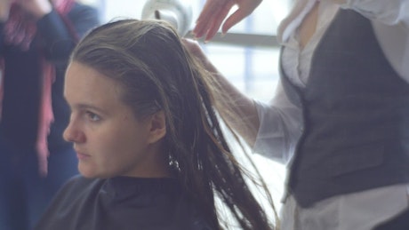 Hairstylist drying woman's long hair