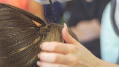Hairstylist hands working on woman's hair
