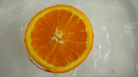 半个橙子在水中漂浮和旋转