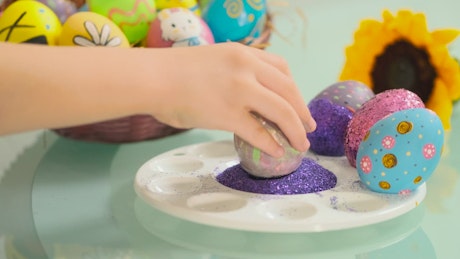 Hand of a girl decorating easter eggs