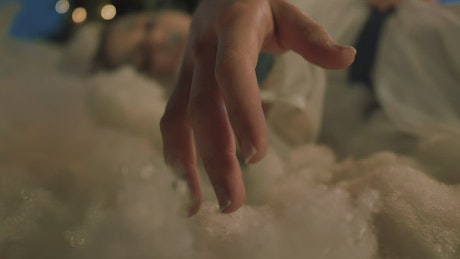 Hand of a girl laying on cotton wool at christmas.