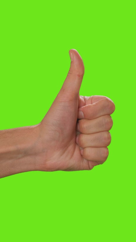 Hand of a person raising the thumb on a green background.