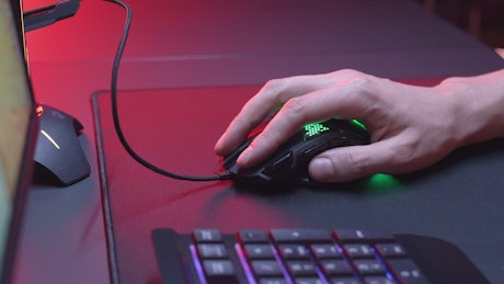 Hand using a gaming a neon lights mouse.
