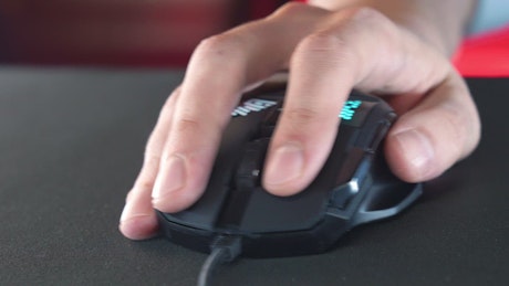Hand using a gaming mouse with RGB neon lightings