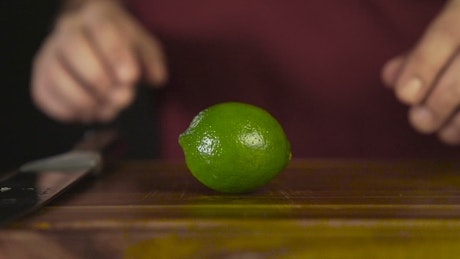 Hands cutting a lime.
