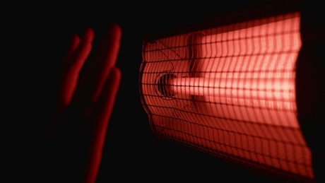 Hands getting close to the electric heater
