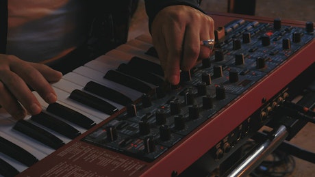 Hands of a DJ playing a keyboard