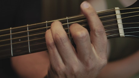 Hands of a guitarist changing chords