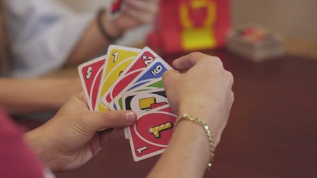 Hands of a person playing a game of UNO.
