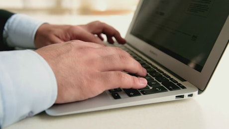 Hands of a person typing on a computer