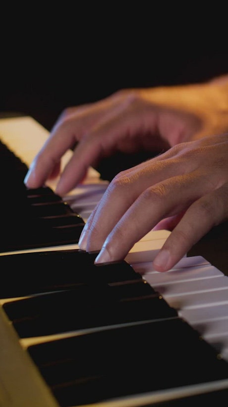 Hands of a pianist playing a keyboard.
