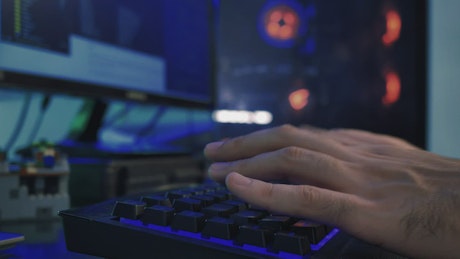 Hands of a programmer working on his computer.